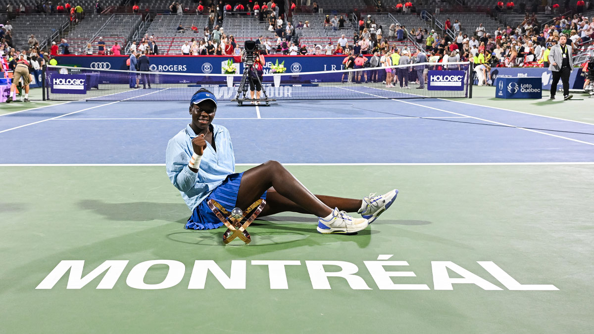 Winner Victoria Mboko (CAN) sits down with her trophy in front of the Montreal logo at IGA Stadium.