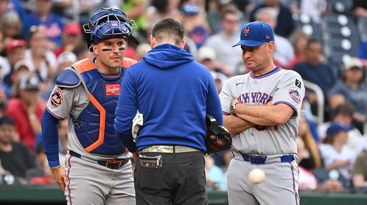 New York Mets manager Carlos Mendoza (64) comes out to check on catcher Luis Torrens (13) after hurting his hand against the Washington Nationals during the third inning at Nationals Park.