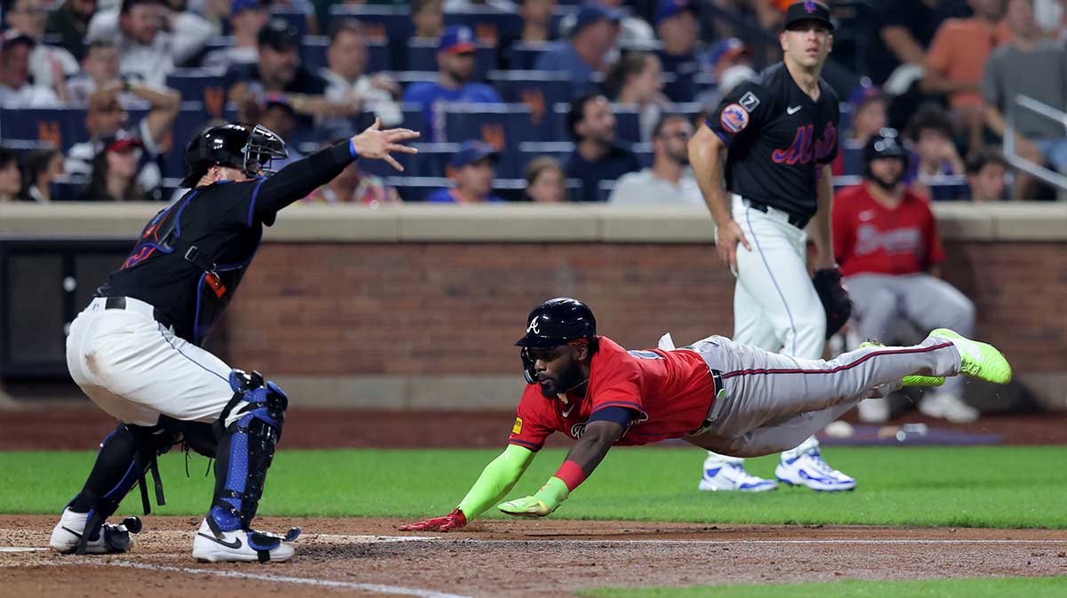 Atlanta Braves center fielder Michael Harris II (23) scores against New York Mets catcher Luis Torrens (13) and relief pitcher Ryan Helsley (56) on a double by Braves second baseman Ozzie Albies (not pictured) during the eighth inning at Citi Field.