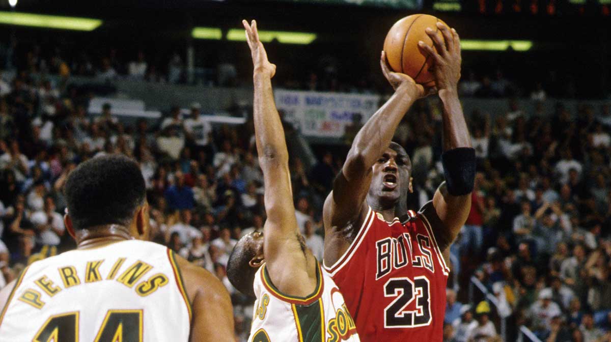 Chicago Bulls guard Michael Jordan shoots over Seattle Supersonics guard Hersey Hawkins (33) during the 1996 NBA Finals at Key Arena.