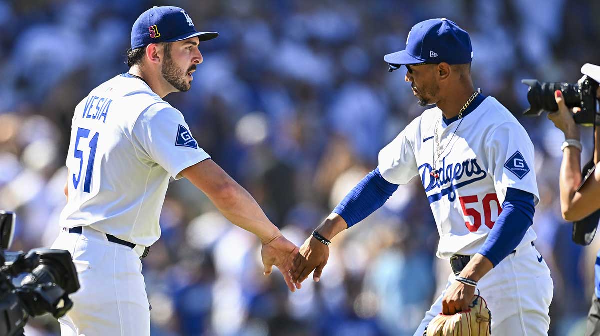 Los Angeles Dodgers pitcher Alex Vesia (51) celebrates with shortstop Mookie Betts (50) after pitching a strike out to defeat the San Diego Padres during the ninth inning at Dodger Stadium.