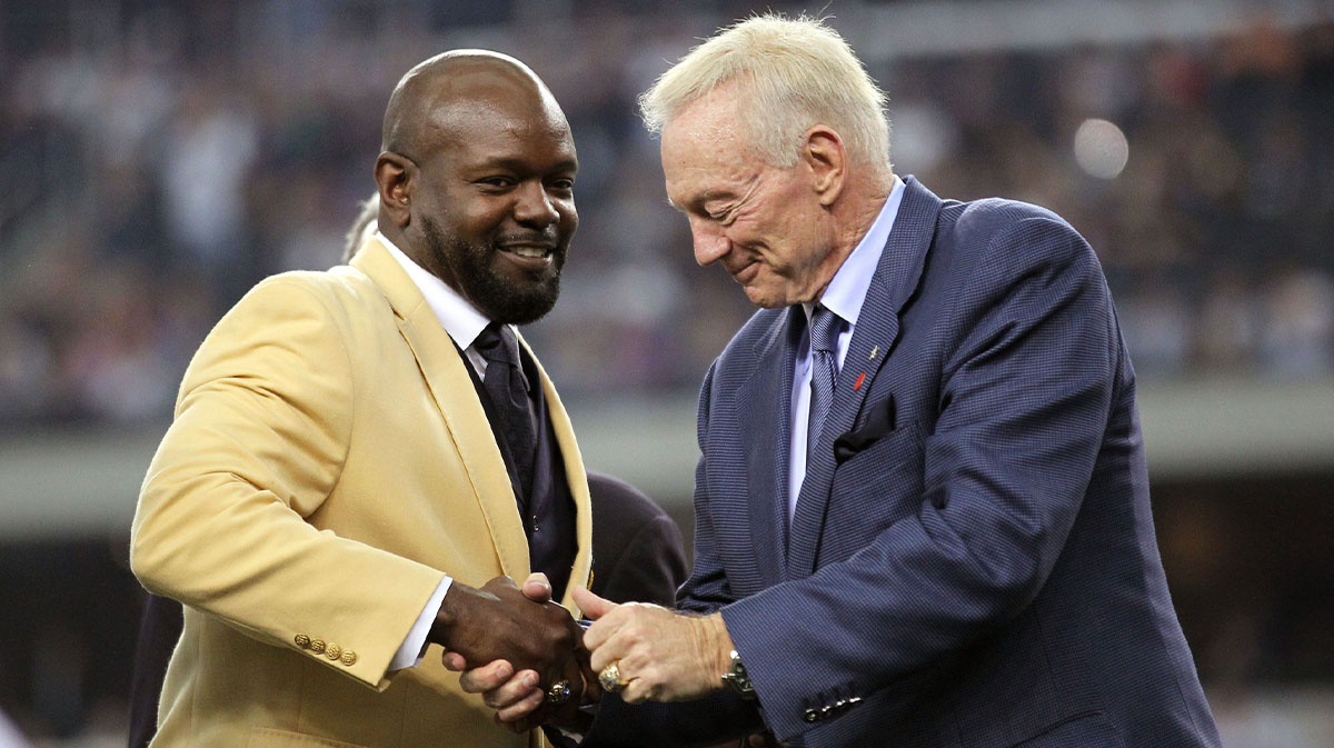 Dallas Cowboys former running back Emmitt Smith (left) shakes owner Jerry Jones hand after being presented his hall of fame ring at halftime of the game against the Detroit Lions at Cowboys Stadium.