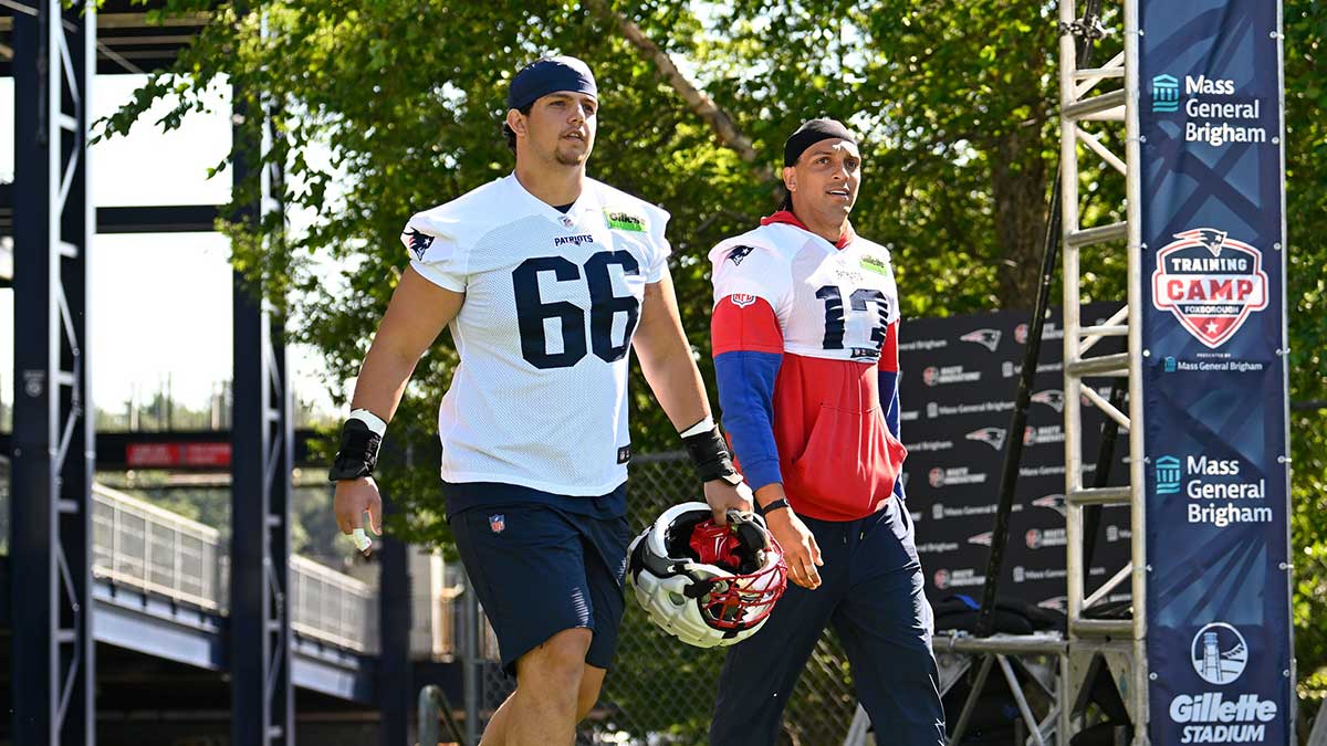 New England Patriots offensive tackle Will Campbell (66) and wide receiver Mack Hollins (13) walk to the practice fields for training camp at Gillette Stadium.