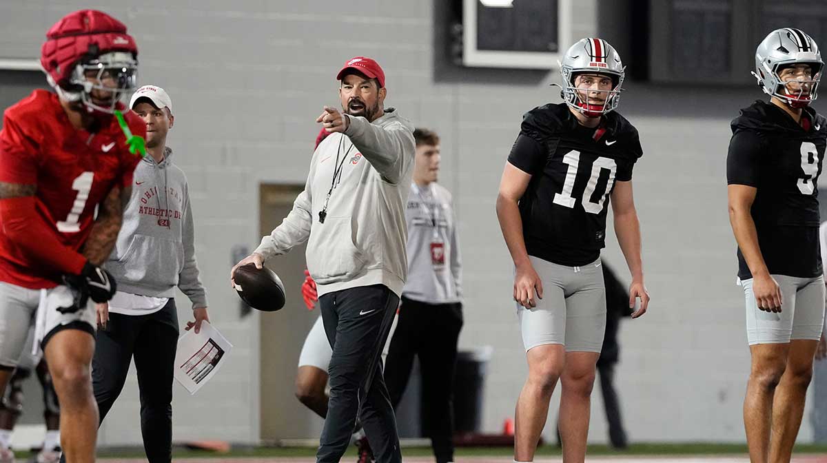 Ohio State Buckeyes head coach Ryan Day works with quarterbacks Julian Sayin (10) and Tavien St. Clair (9) during spring football practice.