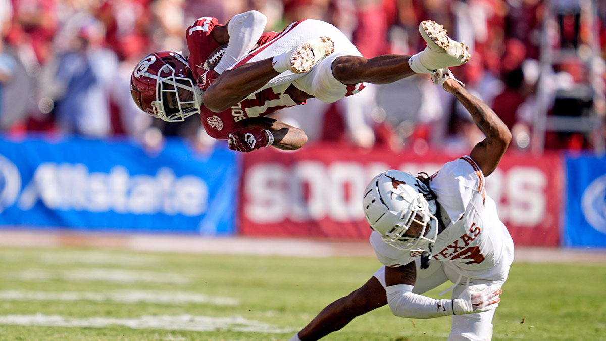 Oklahoma Sooners wide receiver J.J. Hester (13) is up ended by defesive back Jaylon Guilbeau (3) in the first half of the Red River Rivalry college football game between the University of Oklahoma Sooners and the Texas Longhorn at the Cotton Bowl Stadium in Dallas, Texas, Saturday, Oct., 12, 2024.