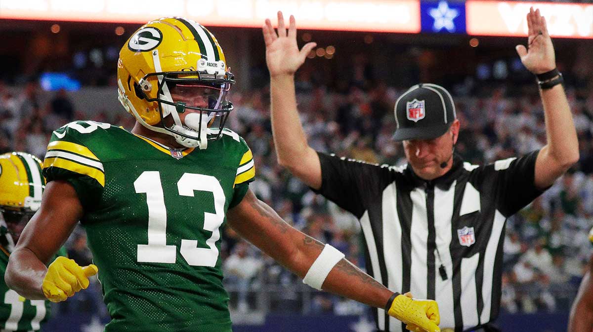 Green Bay Packers wide receiver Dontayvion Wicks (13) celebrates after catching a touchdown pass against Dallas Cowboys linebacker Micah Parsons (11) during the second quarter of their wild card playoff game Sunday, January 14, 2024 at AT&T Stadium in Arlington, Texas.