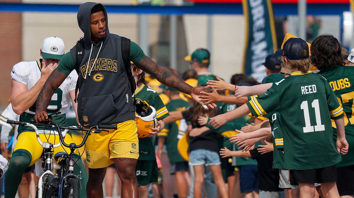 Green Bay Packers wide receiver Matthew Golden slaps hands with young fans as he walks to practice on Thursday, July 31, 2025, at Lambeau Field.