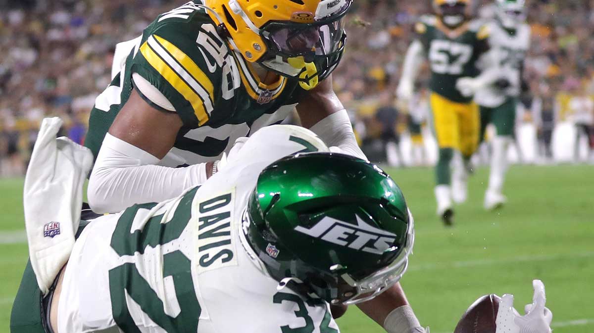 Green Bay Packers cornerback Micah Robinson (26) pushes New York Jets running back Isaiah Davis (32) out of bounds a th the goal line during their football game