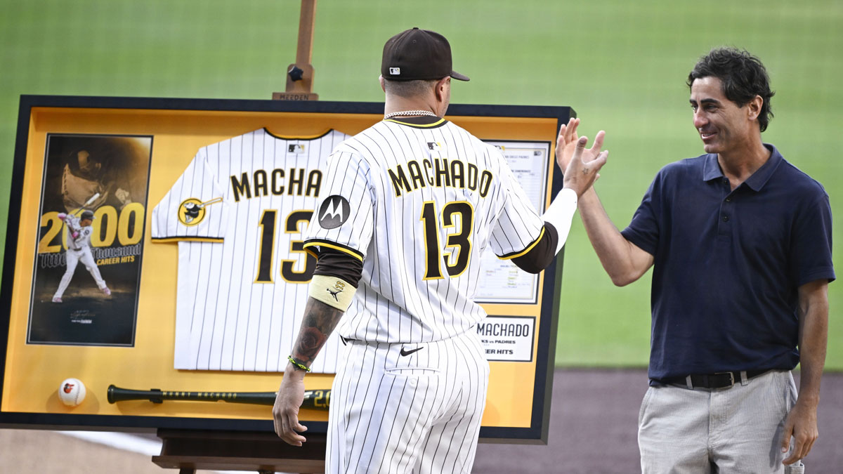 San Diego Padres third baseman Manny Machado (13) shakes hands with general manager A.J. Preller after receiving commemorative memorabilia recognizing his 2,000th hit before a baseball game against the Arizona Diamondbacks at Petco Park.