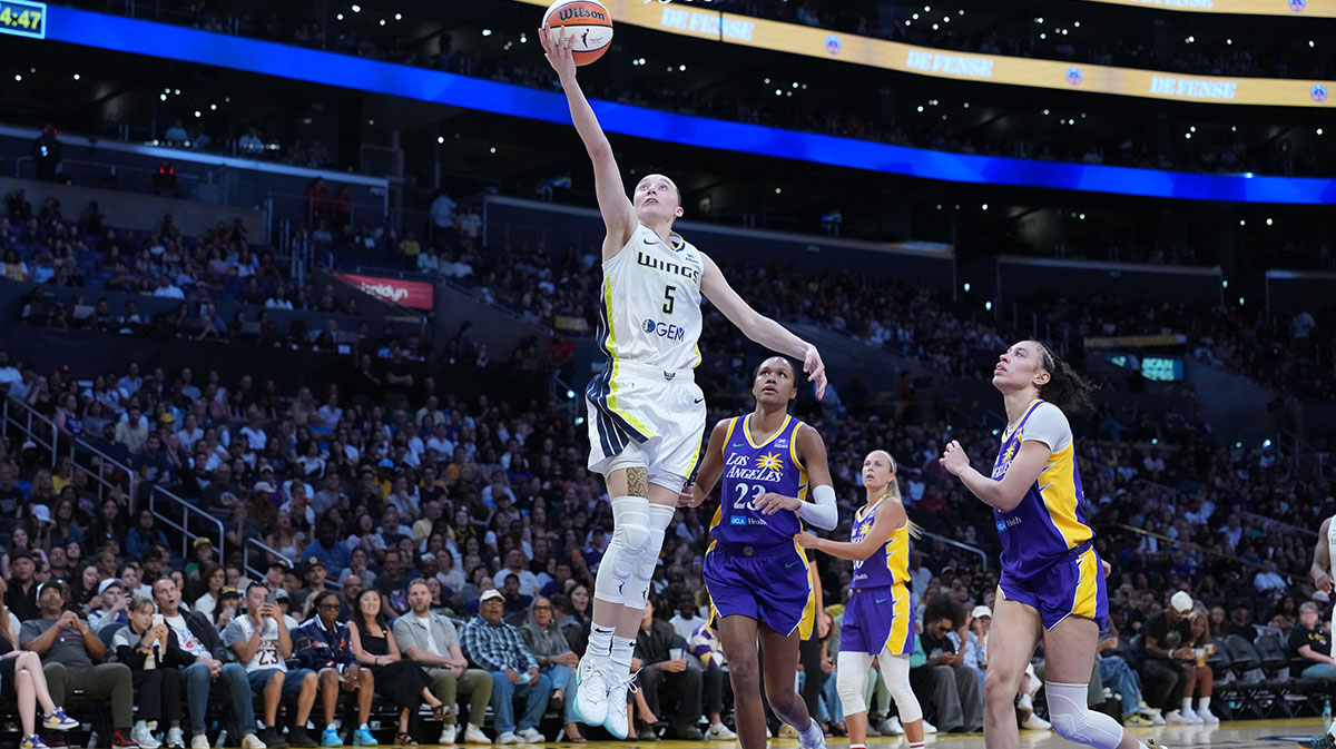 Dallas Wings guard Paige Bueckers (5) shoots the ball against LA Sparks forward Dearica Hamby (5) and forward Azura Stevens (23) in the first half at Crypto.com Arena.