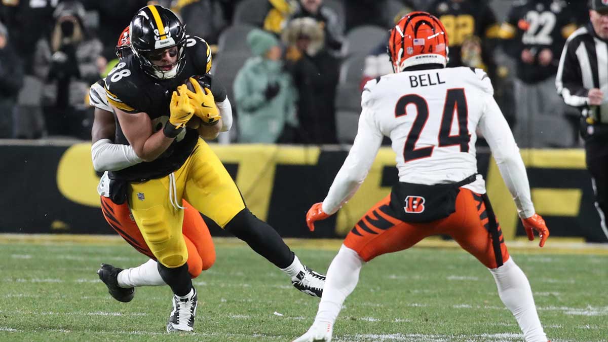Pittsburgh Steelers tight end Pat Freiermuth (88) runs after a catch as Cincinnati Bengals linebacker Akeem Davis-Gaither (rear) and safety Vonn Bell (24) defend during the fourth quarter at Acrisure Stadium.