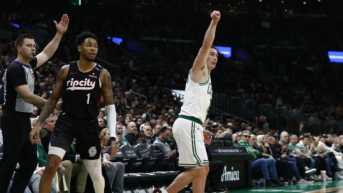 Boston Celtics guard Payton Pritchard (11) follows through on a three point basket as Portland Trail Blazers guard Anfernee Simons (1) looks on during the first quarter at TD Garden.