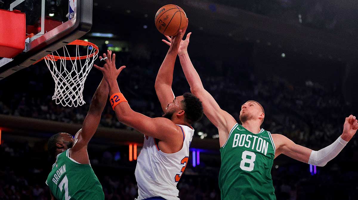Boston Celtics center Kristaps Porzingis (8) blocks a shot by New York Knicks center Karl-Anthony Towns (32) as he drives to the basket against Celtics guard Jaylen Brown (7) during the first quarter of game six in the second round of the 2025 NBA Playoffs at Madison Square Garden.