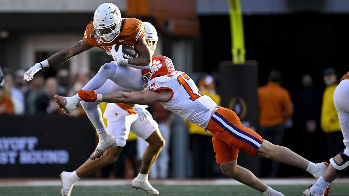 Texas Longhorns running back Quintrevion Wisner (26) leaps over the tackled of Clemson Tigers linebacker Wade Woodaz (17) during the second quarter of the CFP National Playoff first round game at Darrell K Royal-Texas Memorial Stadium.
