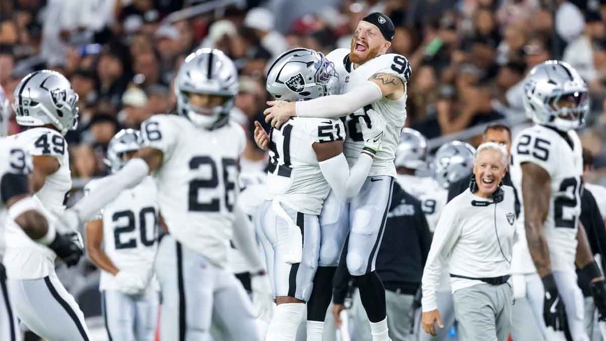 Las Vegas Raiders defensive end Maxx Crosby (98) celebrates a play with Malcolm Koonce (51) against the Arizona Cardinals during a preseason NFL game at State Farm Stadium.