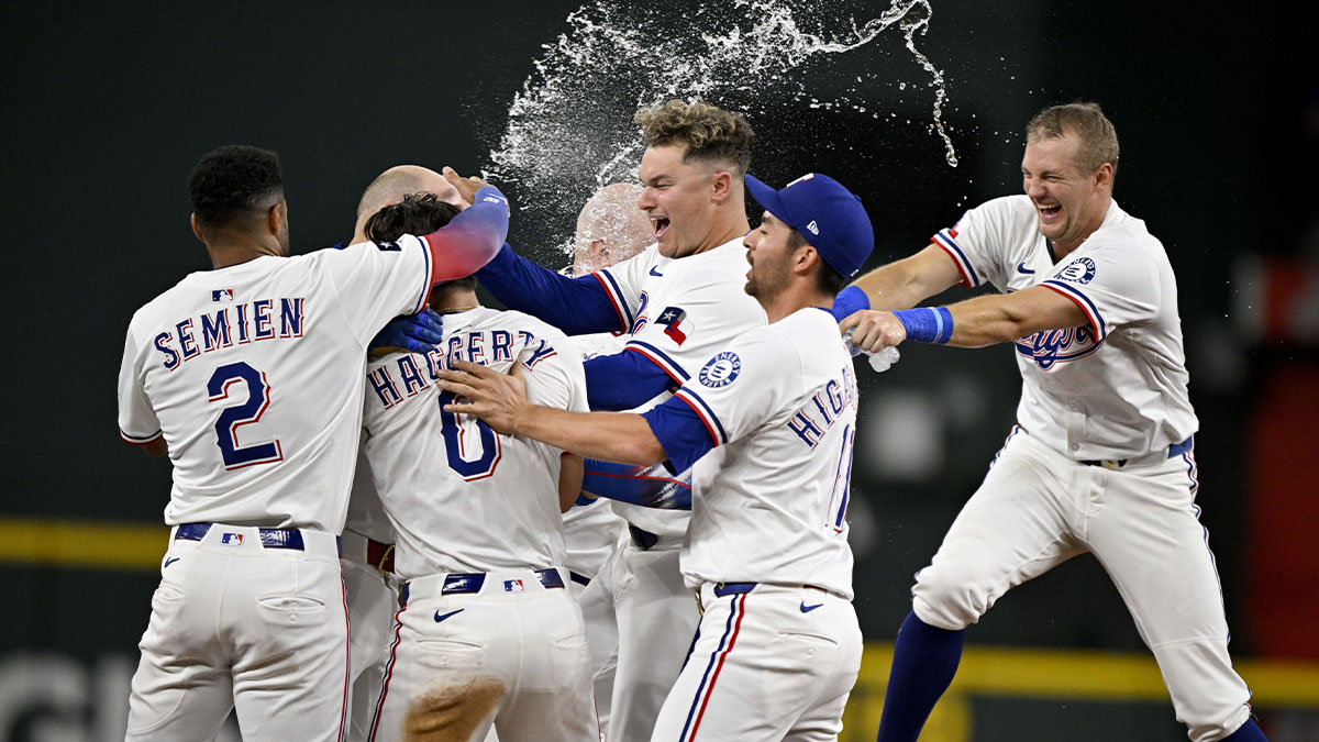 The Texas Rangers celebrate after pinch hitter Jake Burger (21) drives in the game winning run during the tenth inning at Globe Life Field.
