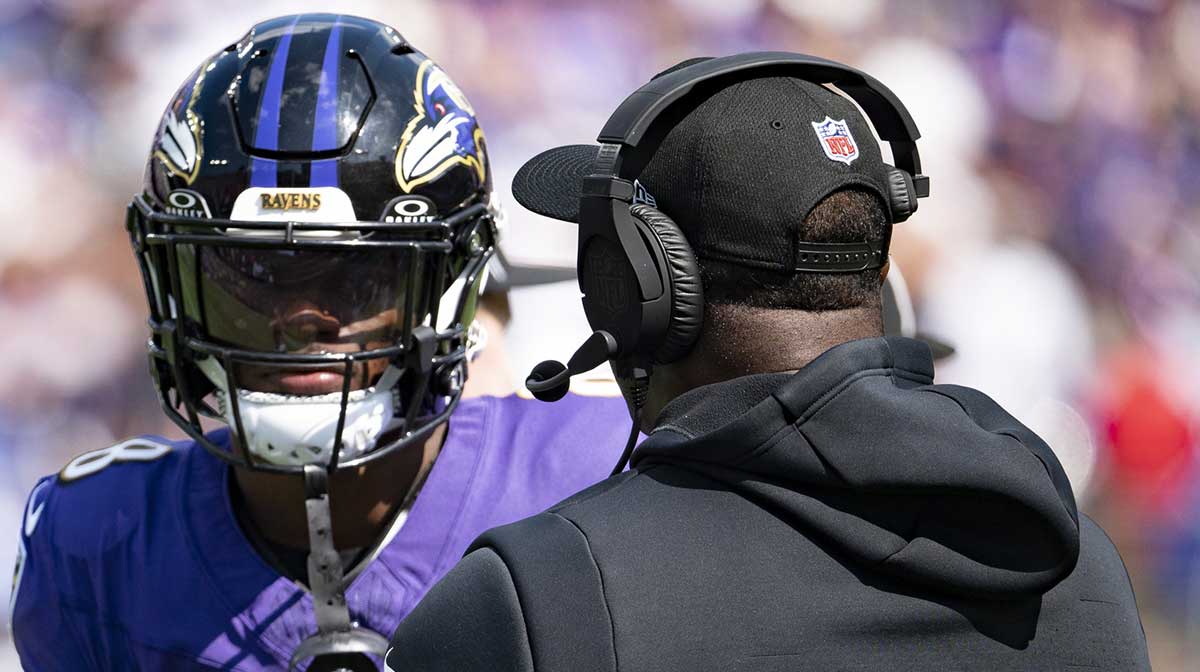 Baltimore Ravens quarterback Lamar Jackson (8) speaks with quarterback coach Tee Martin during the first half against the Las Vegas Raiders at M&T Bank Stadium.