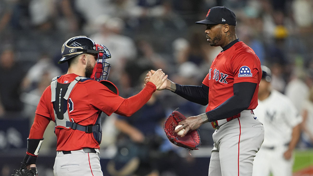 Boston Red Sox manager Alex Cora (13) and pitcher Aroldis Chapman (44) shake hands to celebrate the victory against the New York Yankees after the ninth inning at Yankee Stadium.