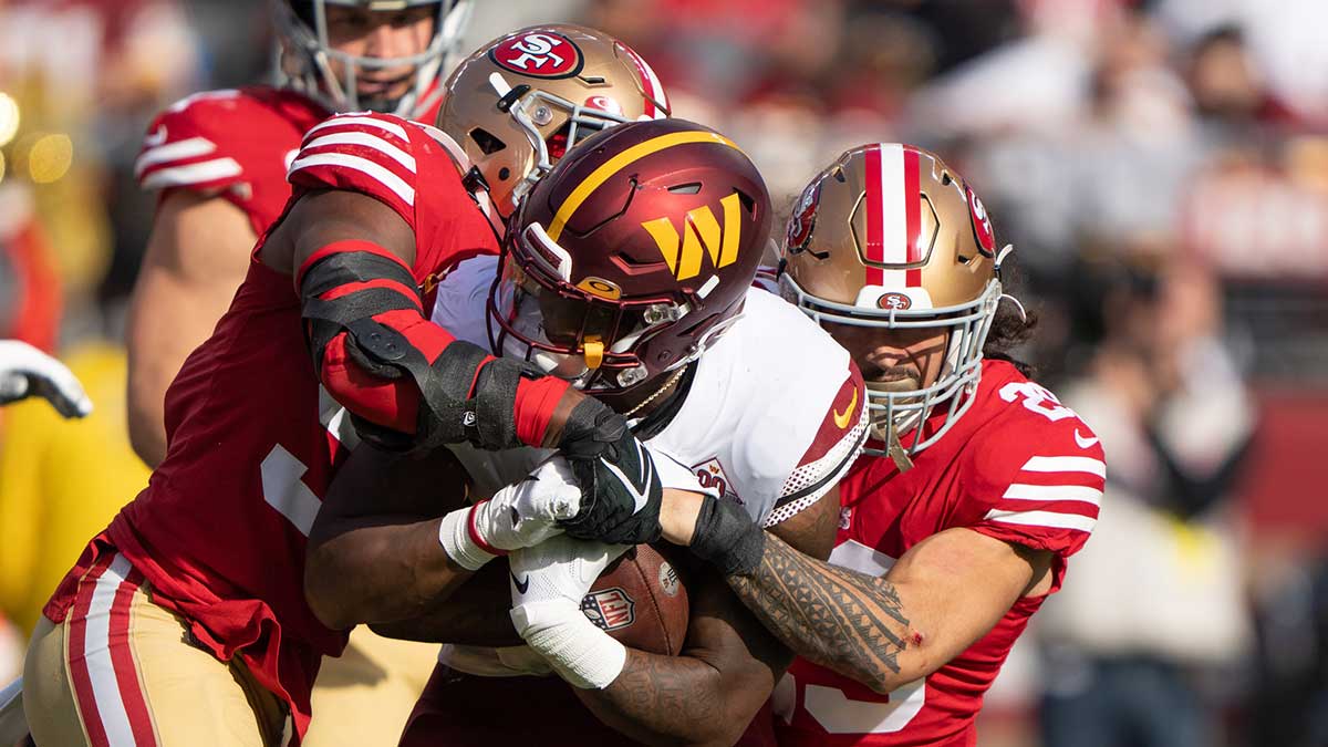San Francisco 49ers linebacker Dre Greenlaw (57) and safety Talanoa Hufanga (29) tackle Washington Commanders running back Brian Robinson Jr. (8) during the first quarter at Levi's Stadium.
