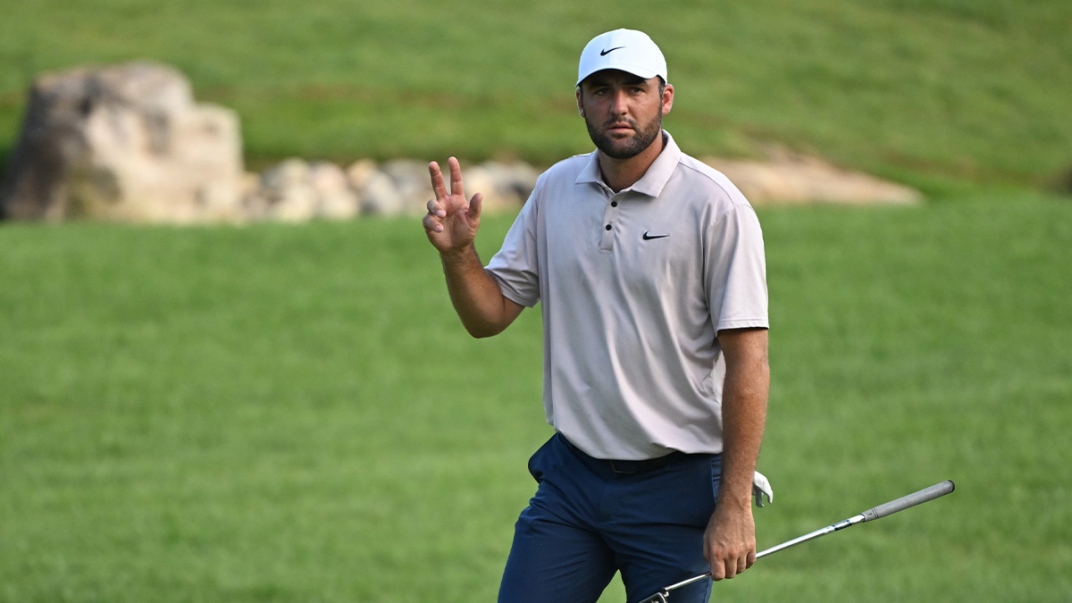 Scottie Scheffler waives to the crowd on the 18th hole during the third round of the BMW Championship golf tournament.