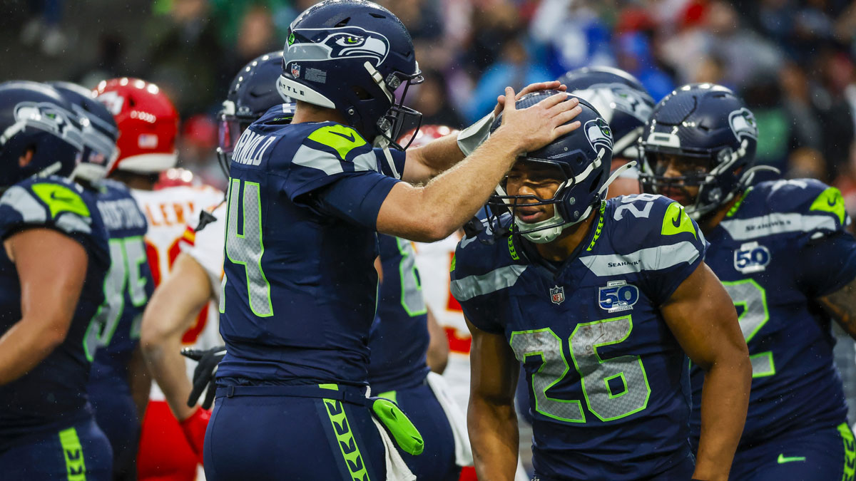 Seattle Seahawks running back Zach Charbonnet (26) celebrates with quarterback Sam Darnold (14) after rushing for a touchdown against the Kansas City Chiefs during the first quarter at Lumen Field.