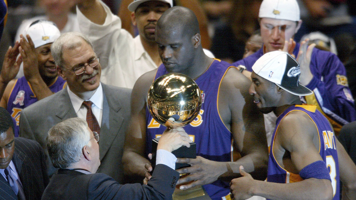 NBA commissioner David Stern hands Los Angeles Lakers Phil Jackson (left), Shaquille O'Neal (center) and Kobe Bryant (right) their championship trophy at the end of Game 4 of the NBA Finals at The Meadowlands.
