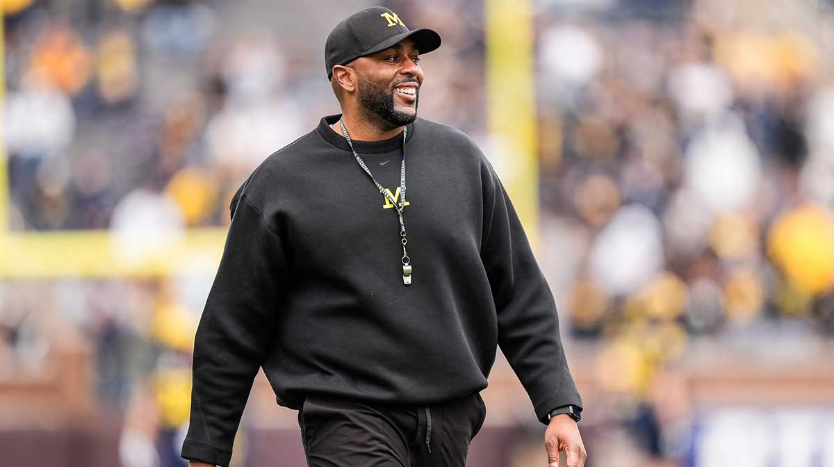 Michigan head coach Sherrone Moore smiles at players as he watches the first half of the spring game at Michigan Stadium in Ann Arbor on Saturday, April 19, 2025.