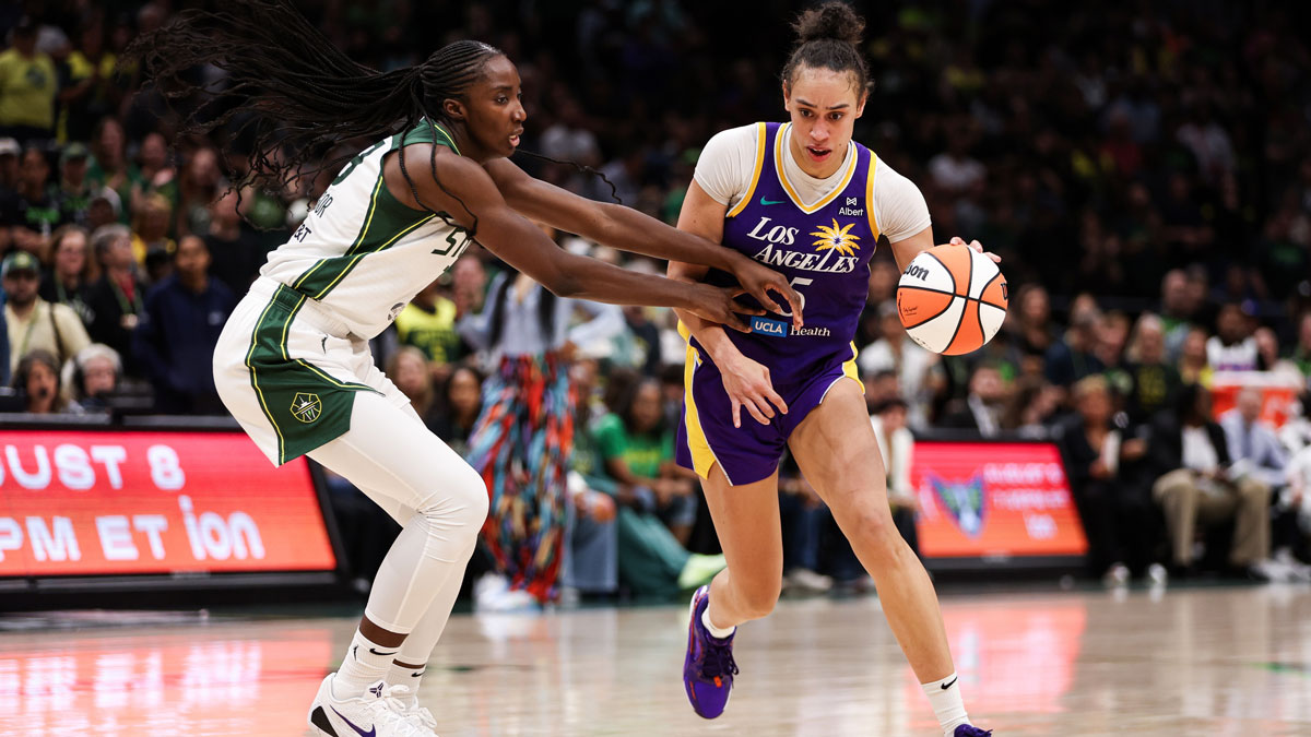 Los Angeles Sparks forward Dearica Hamby (5) drives the ball past Seattle Storm forward Ezi Magbegor (13) during overtime at Climate Pledge Arena.