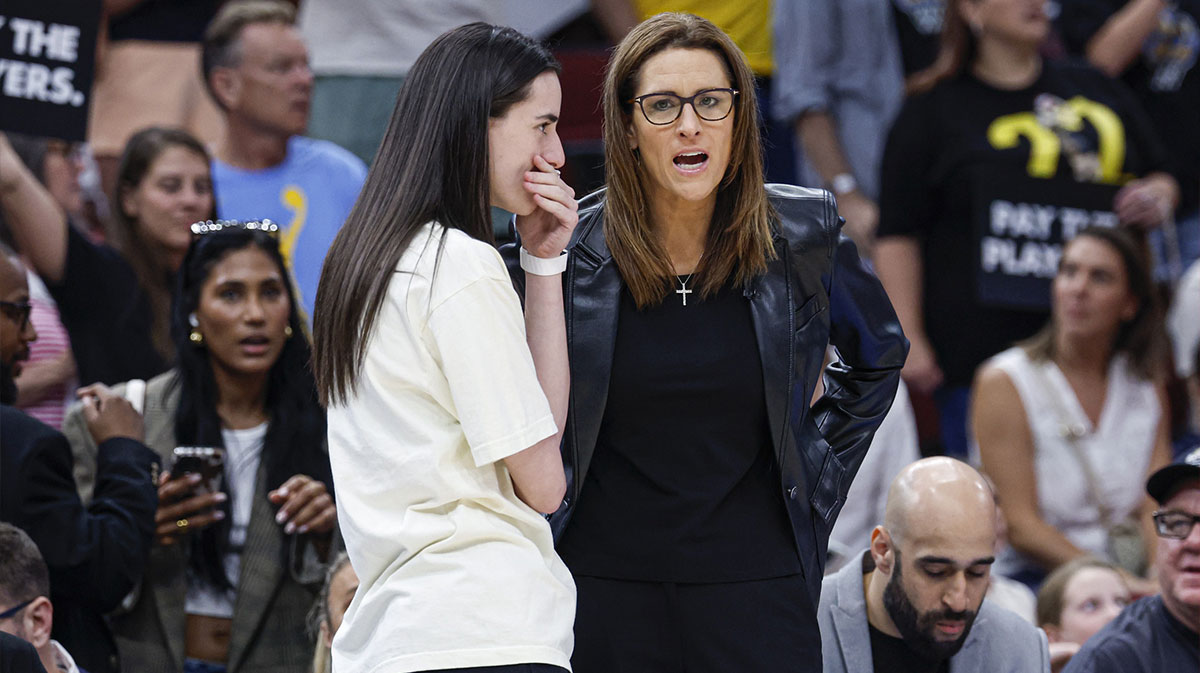 Indiana Fever head coach Stephanie White (R) talks to injured guard Caitlin Clark (L) before a basketball game against the Chicago Sky at United Center.