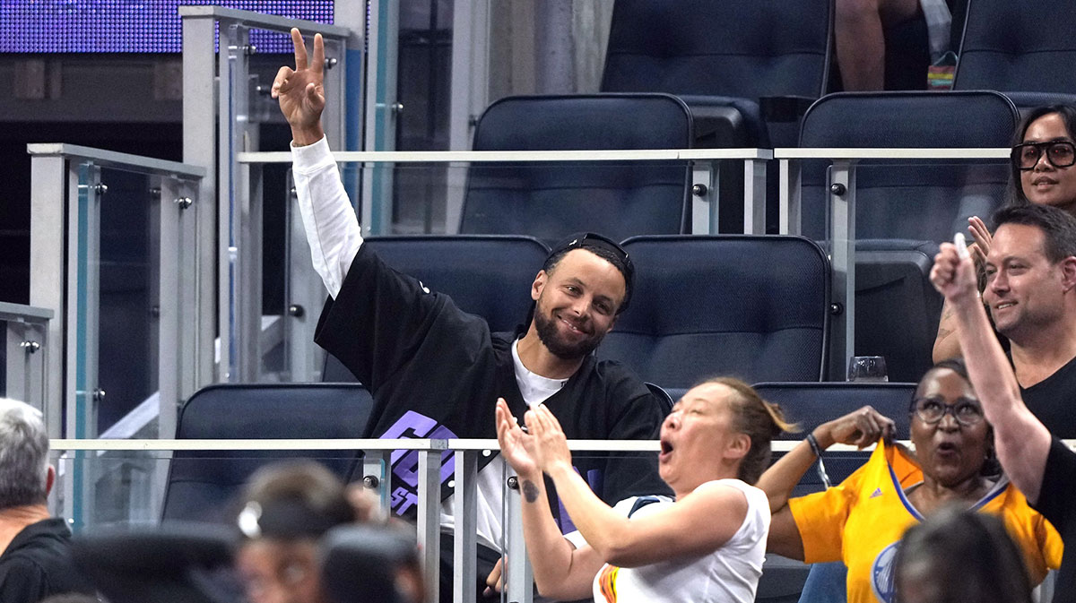 Golden State Warriors guard Stephen Curry (center) waves during the second quarter of the game between the Golden State Valkyries and the Seattle Storm at Chase Center.