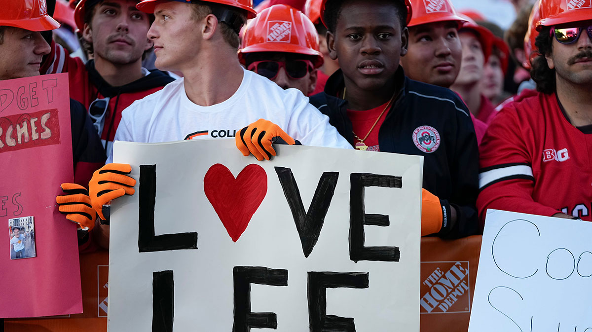 Fans hold signs in support of Lee Corso on the set of ESPN College GameDay prior to the NCAA football game between the Ohio State Buckeyes and the Texas Longhorns at Ohio Stadium.