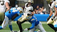 New Orleans Saints quarterback Jake Haener (3) is pressured by Los Angeles Chargers defensive tackle TeRah Edwards (94) and linebacker Garmon Randolph (97) in the second half at SoFi Stadium.