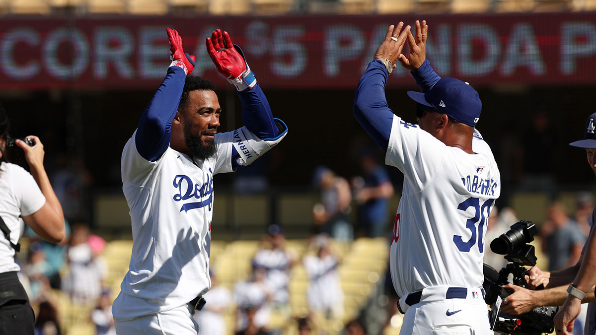 Los Angeles Dodgers left fielder Teoscar Hernandez (37) celebrates with manager Dave Roberts (30) after hitting a game winning RBI single in bottom of the tenth inning against the Pittsburgh Pirates at Dodger Stadium