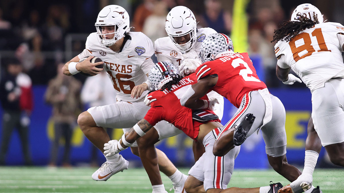 Texas Longhorns quarterback Arch Manning (16) runs against Ohio State Buckeyes cornerback Jordan Hancock (7) and safety Caleb Downs (2) during the second quarter of the College Football Playoff semifinal in the Cotton Bowl at AT&T Stadium.
