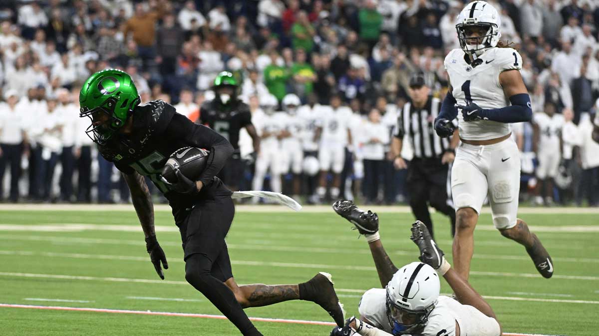 Oregon Ducks wide receiver Tez Johnson (15) runs for a gain and avoids the tackle from Penn State Nittany Lions safety Zakee Wheatley (6) during the third quarter in the 2024 Big Ten Championship game at Lucas Oil Stadium.