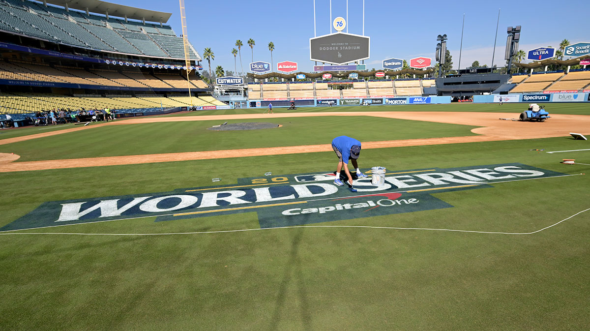 Stadium workers paint the World Series logo on the field prior to team workouts at Dodgers Stadium.