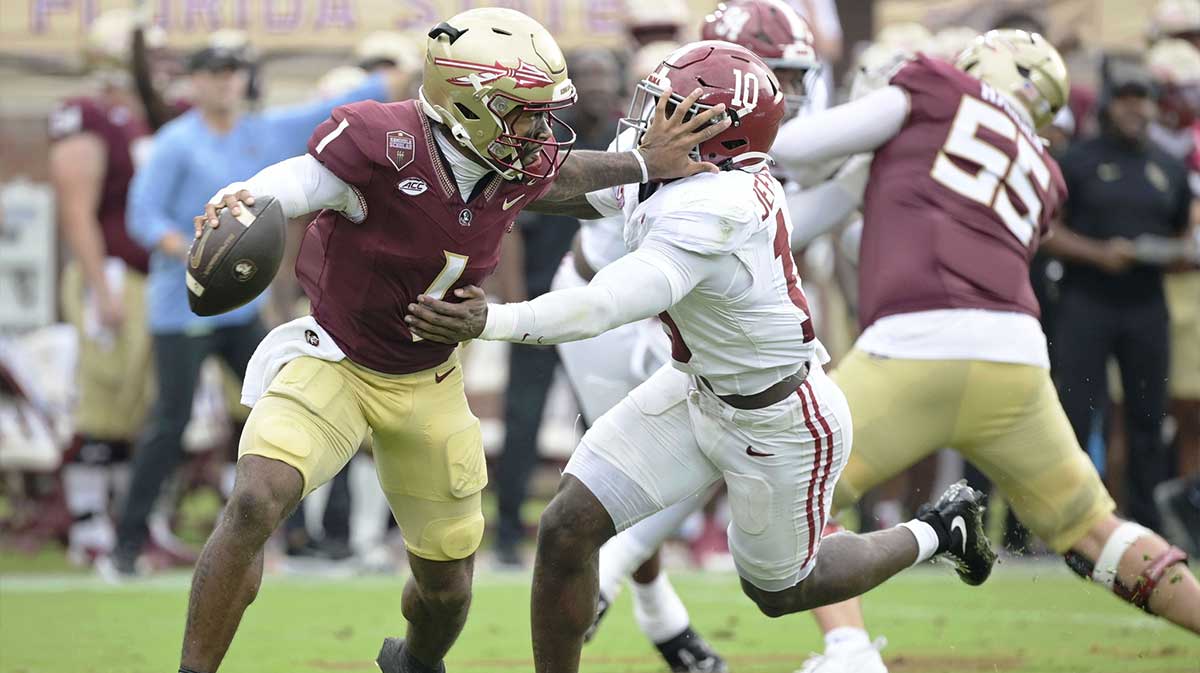 Florida State Seminoles quarterback Tommy Castellanos (1) stiff arms Alabama Crimson Tide linebacker Justin Jefferson (10) during the second half at Doak S. Campbell Stadium.