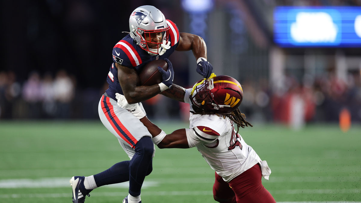 Washington Commanders saftey Tyler Owens (40) tries to tackle New England Patriots running back TreVeyon Henderson (32) during the first half at Gillette Stadium.