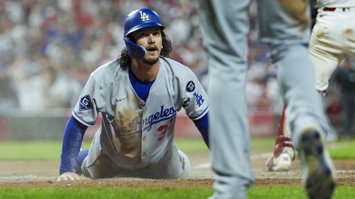 Los Angeles Dodgers outfielder James Outman (33) scores a run on a double hit by catcher Will Smith (16) in the game against the Cincinnati Reds in the ninth inning at Great American Ball Park.