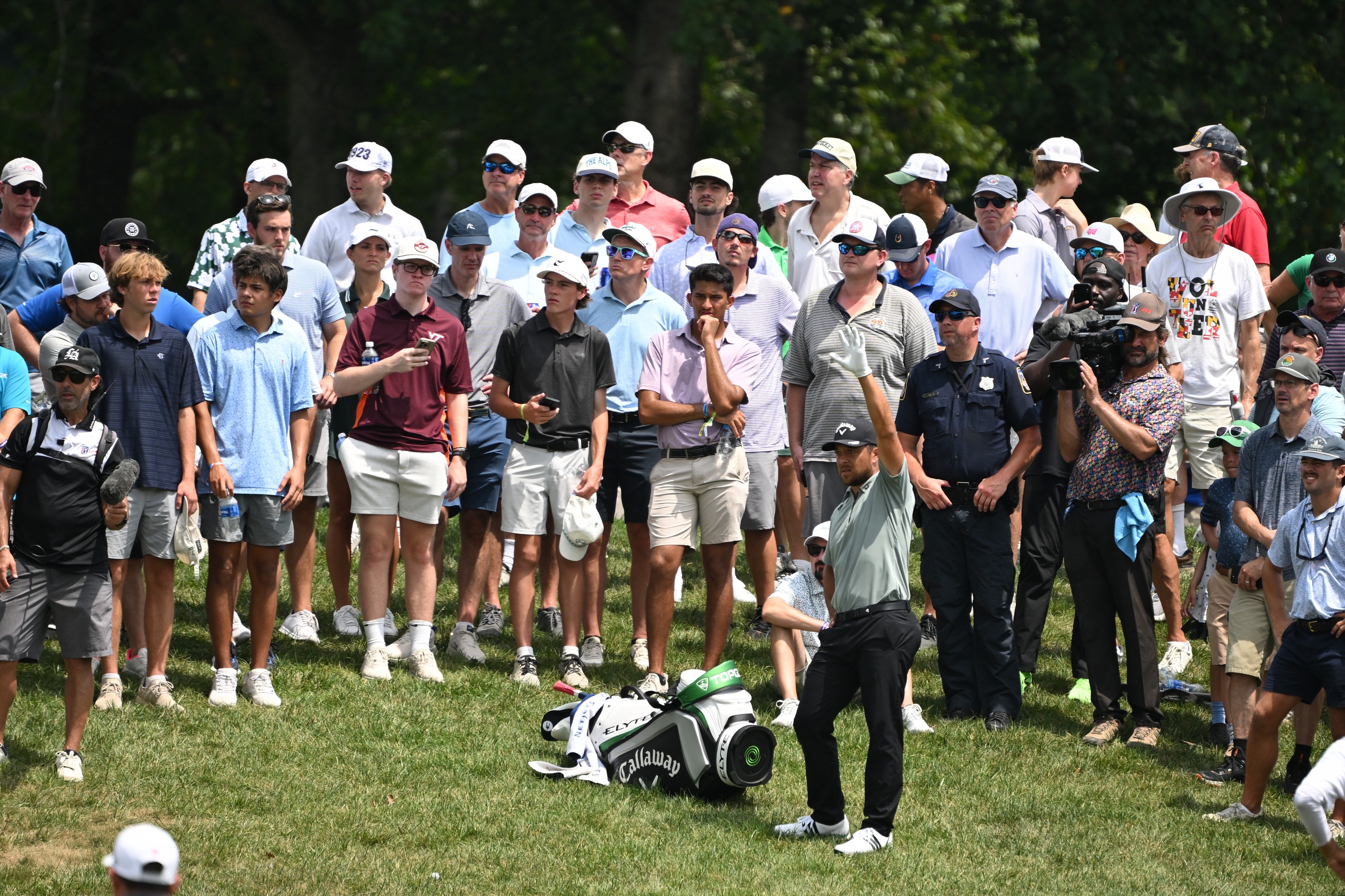 Xander Schauffele prepares to hit a shot while surrounded by the gallery on the 16th hole during the first round of the BMW Championship golf tournament