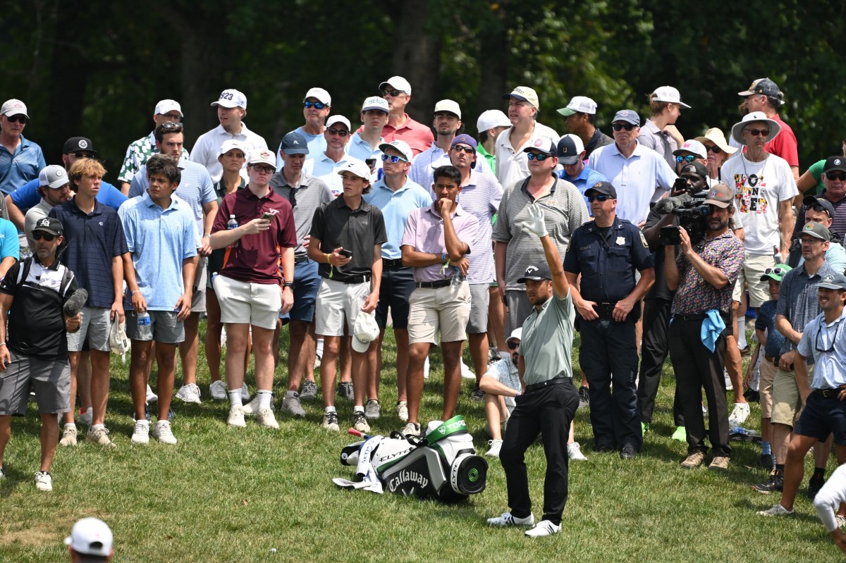 Xander Schauffele prepares to hit a shot while surrounded by the gallery on the 16th hole during the first round of the BMW Championship golf tournament