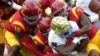 Notre Dame Fighting Irish running back Jeremiyah Love (4) is stopped by the Southern California Trojans defense during the first half at the Los Angeles Memorial Coliseum.