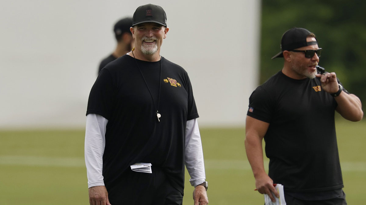 Washington Commanders head coach Dan Quinn (M) smiles during warm up before practice on day one of training camp at OrthoVirginia Training Center at Commanders Park.