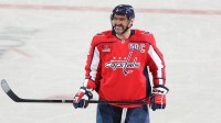 Washington Capitals left wing Alex Ovechkin (8) smiles from the ice after scoring a goal against the Chicago Blackhawks in the third period at Capital One Arena. The goal is the 894th of his career, tying Wayne Gretzky (not pictured) for most all-time goals scored in the NHL.