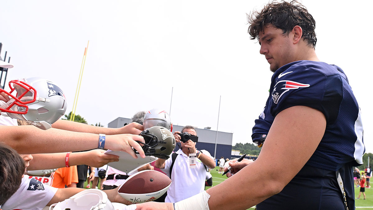New England Patriots offensive tackle Will Campbell (66) signs autographs after training camp at Gillette Stadium.