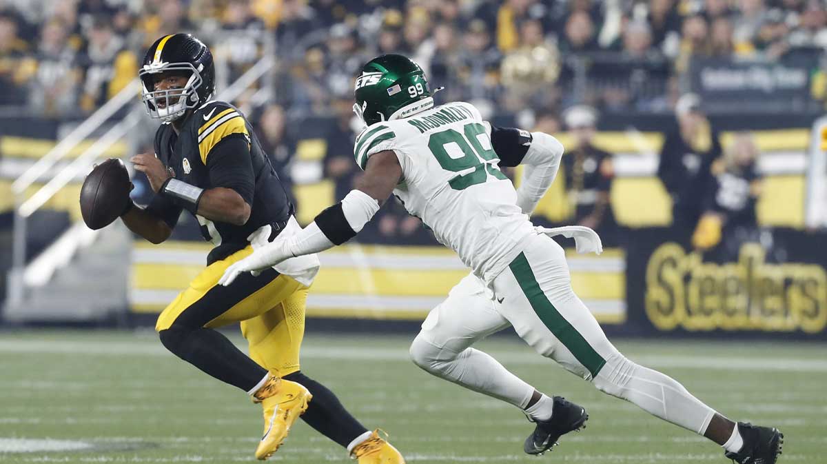 Oct 20, 2024; Pittsburgh, Pennsylvania, USA; Pittsburgh Steelers quarterback Russell Wilson (3) scrambles against pressure from New York Jets defensive end Will McDonald IV (99) during the first quarter at Acrisure Stadium.