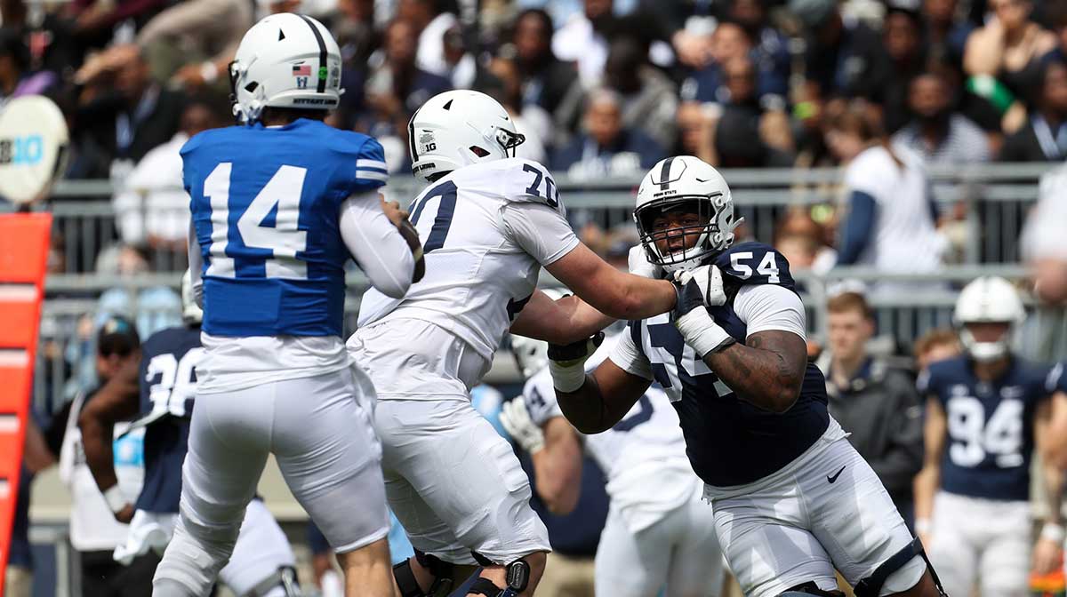 Penn State Nittany Lions defensive tackle Xavier Gilliam (54) attempts to pressure quarterback Jaxon Smolik (14) during the second quarter of the Blue White spring game at Beaver Stadium. The White team defeated the Blue team 10-8. 