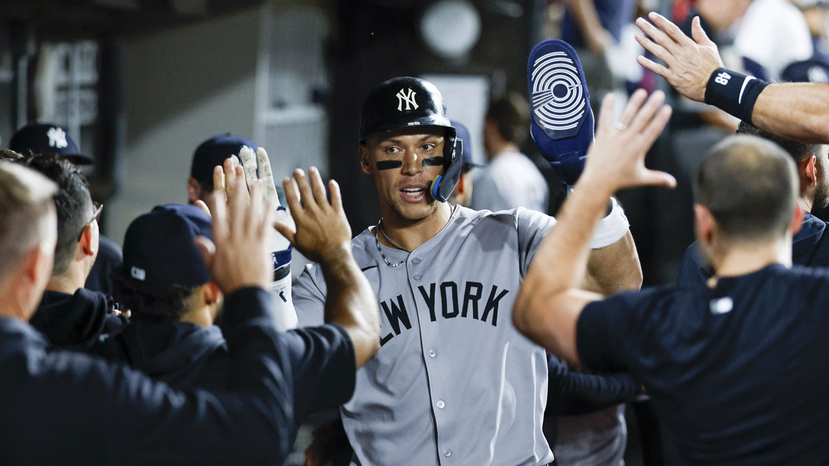 New York Yankees designated hitter Aaron Judge (99) celebrates with teammates in the dugout after scoring against the Chicago White Sox during the 11th inning at Rate Field.