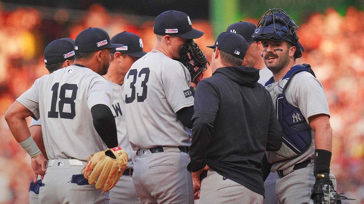 New York Yankees pitcher Ryan Yarbrough (33) talks with pitching coach Matt Blake (77) and teammates as they take on the Boston Red Sox in the first inning at Fenway Park. Yankees face tough bullpen choices as Ryan Yarbrough and Fernando Cruz near return, with Matt Blake preparing for hard roster decisions down the stretch.