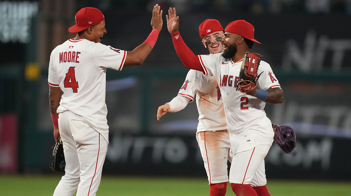 Los Angeles Angels second baseman Christian Moore (4), shortstop Zach Neto (9) and second baseman Luis Rengifo (2) celebrate after the game against the Los Angeles Dodgers at Angel Stadium.